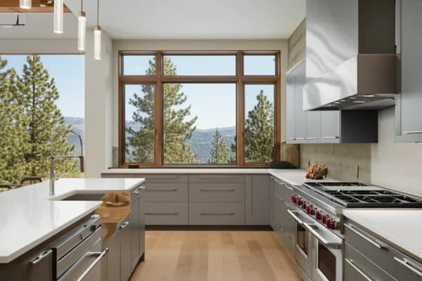 Design concept for a mountain-modern kitchen with natural wood cabinetry, a long stone island, and a view wall, the kind of room suited to a Northstar custom home