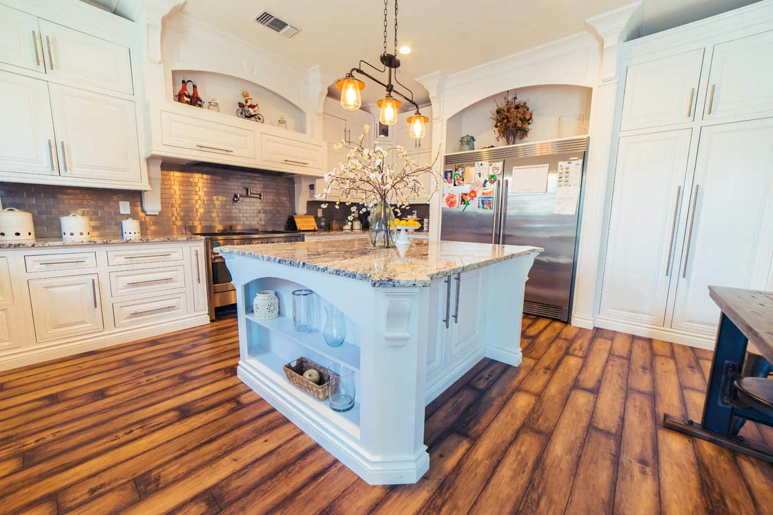 Design concept for a low flush kitchen run under exposed beams beside a floor-to-ceiling glass wall in a post-and-beam home